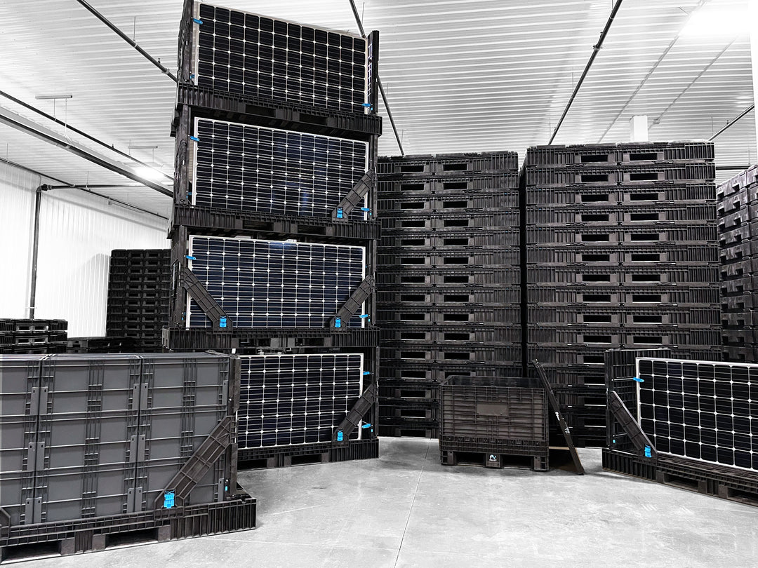 Straight wall containers, solar panel pallets, and a collapsible bulk container with lid displayed in a warehouse with stacked plastic pallets in the background