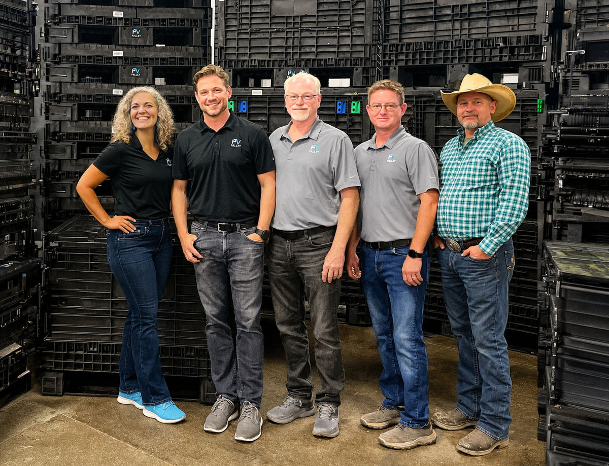 Pallets & Bins / PVpallet team standing together in front of stacked bulk containers in PVpallet warehouse. 